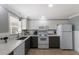 A lovely kitchen featuring white cabinets, gray lower cabinets, and stainless steel appliances at 415 63Rd St, Holmes Beach, FL 34217