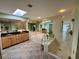 Bright bathroom with skylight, glass-enclosed shower, and soaking tub with tile surround at 417 Firethorn Ave, Englewood, FL 34223
