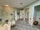 Bathroom with tile flooring, glass shower, soaking tub and mirrored closet at 417 Firethorn Ave, Englewood, FL 34223