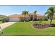 Charming single-story home with a well-manicured lawn and vibrant landscaping, including palm trees and a decorative rock garden at 417 Firethorn Ave, Englewood, FL 34223