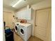 Functional laundry room equipped with modern washer and dryer, ample cabinet storage, and a utility sink at 417 Firethorn Ave, Englewood, FL 34223