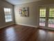 Bright, airy bedroom with hardwood floors, a stylish painting, and a door leading to an outdoor balcony at 4375 Trails Dr # 17-1, Sarasota, FL 34232