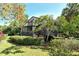 Charming home exterior with a wooden porch, surrounded by lush greenery and mature trees at 4375 Trails Dr # 17-1, Sarasota, FL 34232