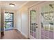 Bright hallway featuring wood flooring and access to a screened porch through glass paneled doors at 4375 Trails Dr # 17-1, Sarasota, FL 34232
