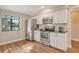 Well-lit kitchen featuring stainless steel appliances, white cabinets, and wood-look flooring at 4375 Trails Dr # 17-1, Sarasota, FL 34232