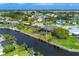 Aerial view of a waterfront home with a pool, dock, lush greenery, and a tranquil canal, capturing outdoor Florida living at 4704 Coral Lake Dr, Bradenton, FL 34210