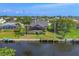 Backyard view featuring a pool, tropical landscaping, canal access, and a private boat dock create an ideal waterfront oasis at 4704 Coral Lake Dr, Bradenton, FL 34210