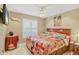 Bedroom with a ceiling fan, a colorful comforter and plantation shutters at 4704 Coral Lake Dr, Bradenton, FL 34210
