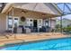 Inviting covered patio features an outdoor seating area with ceiling fans near the screened pool at 4704 Coral Lake Dr, Bradenton, FL 34210
