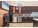 Kitchen area with wine storage, stainless steel appliances, granite countertops, and dark wood cabinetry at 4704 Coral Lake Dr, Bradenton, FL 34210