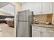 View of the kitchen with white cabinets, stainless refrigerator and granite countertops and open to the living room at 4704 Coral Lake Dr, Bradenton, FL 34210