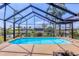 Sparkling pool enclosed within a screened lanai offering serene water views and lush landscaping at 4704 Coral Lake Dr, Bradenton, FL 34210