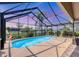 This screened-in pool features clear blue water, a charming waterfront view and lush tropical landscaping at 4704 Coral Lake Dr, Bradenton, FL 34210