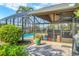 Backyard patio with private pool, lush greenery, and convenient access to screened in seating at 4704 Coral Lake Dr, Bradenton, FL 34210