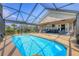 Enclosed pool adjacent to a covered patio features an outdoor sitting area with waterfront views at 4704 Coral Lake Dr, Bradenton, FL 34210