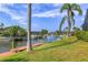 Scenic waterfront view with a private dock, lush greenery, and clear blue skies creates a peaceful outdoor oasis at 4704 Coral Lake Dr, Bradenton, FL 34210