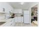 Well-lit kitchen featuring sleek white cabinetry, modern appliances, and granite countertops at 5309 Myrtle Wood Rd # 43, Sarasota, FL 34235