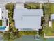 Aerial view of the home featuring a metal roof, private dock, and pool nestled within tropical landscaping at 600 De Narvaez Dr, Longboat Key, FL 34228