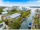 Stunning waterfront home with private dock, boat, and lush tropical landscaping on a sunny day at 600 De Narvaez Dr, Longboat Key, FL 34228