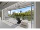 Bright balcony with comfortable seating overlooks lush tropical landscaping at 600 De Narvaez Dr, Longboat Key, FL 34228