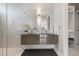 A bright bathroom featuring double vanity, sleek cabinets, and a glass shower with luxurious details at 600 De Narvaez Dr, Longboat Key, FL 34228