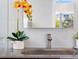 A detailed shot of the bathroom, showing the sink, faucet and a vibrant floral arrangement next to the mirror at 600 De Narvaez Dr, Longboat Key, FL 34228