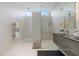 This bathroom features a glass shower, double vanity, sleek cabinets, modern fixtures and stylish wall lighting at 600 De Narvaez Dr, Longboat Key, FL 34228