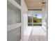 Bright bedroom with textured glass doors, large windows, and view of tropical foliage at 600 De Narvaez Dr, Longboat Key, FL 34228