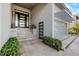 Elegant entryway featuring modern glass doors, stone steps, and manicured bushes at 600 De Narvaez Dr, Longboat Key, FL 34228