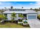 Beautiful modern home with a metal roof, elegant landscaping, and a stylish glass garage door at 600 De Narvaez Dr, Longboat Key, FL 34228