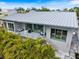 Modern home exterior with a metal roof, balcony, and a private pool surrounded by lush landscaping at 600 De Narvaez Dr, Longboat Key, FL 34228