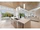 Open kitchen design with island and sink overlooking the dining area and living room in a modern setting at 600 De Narvaez Dr, Longboat Key, FL 34228