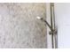 Stylish shower features a shower head and textured decorative tile at 600 De Narvaez Dr, Longboat Key, FL 34228