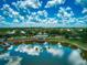 An aerial view of a pond and dock surrounded by lush trees and landscaping, reflected in the water at 6605 Waters Edge Way, Lakewood Ranch, FL 34202