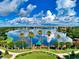 Aerial view of community on lake with a gazebo, palm trees and reflective skies at 6605 Waters Edge Way, Lakewood Ranch, FL 34202