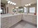 Bathroom featuring double sinks with marble countertops and ample storage space at 6605 Waters Edge Way, Lakewood Ranch, FL 34202