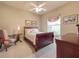 Bedroom with a carved wood sleigh bed, colorful accents, and neutral-toned walls at 6605 Waters Edge Way, Lakewood Ranch, FL 34202