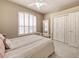 Cozy bedroom with carpeted floors, ceiling fan, shuttered windows, and double door closet at 6605 Waters Edge Way, Lakewood Ranch, FL 34202