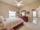 Bedroom with a carved wood sleigh bed, neutral-toned walls, and an ensuite bathroom at 6605 Waters Edge Way, Lakewood Ranch, FL 34202