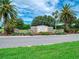 Community entrance with palm trees, stone signage, manicured landscaping, and a clear blue sky at 6605 Waters Edge Way, Lakewood Ranch, FL 34202