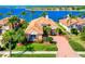 Waterfront home showcasing a tile roof, brick driveway, and meticulously manicured landscaping at 6605 Waters Edge Way, Lakewood Ranch, FL 34202
