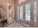 Inviting foyer featuring tile flooring, decorative walls, and a glass-paneled front door with plantation shutters at 6605 Waters Edge Way, Lakewood Ranch, FL 34202
