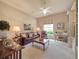 Living room with a ceiling fan, carpet floors, and a leather couch at 6605 Waters Edge Way, Lakewood Ranch, FL 34202