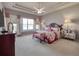 Large main bedroom with tray ceiling, sitting area, and serene water views at 6605 Waters Edge Way, Lakewood Ranch, FL 34202