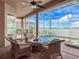 Relaxing screened-in patio overlooking waterfront with a hot tub and seating area at 6605 Waters Edge Way, Lakewood Ranch, FL 34202