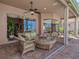 Outdoor patio area with water views featuring comfortable seating and a glimpse into the living room at 6605 Waters Edge Way, Lakewood Ranch, FL 34202
