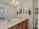Bright bathroom featuring double sinks and wood cabinets with a large mirror at 6611 Grand Estuary Trl # 105, Bradenton, FL 34212