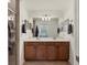 Bathroom featuring double sinks, a large mirror, and wood cabinetry at 6611 Grand Estuary Trl # 105, Bradenton, FL 34212
