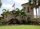 Beautiful clubhouse exterior with stone accents, mature palm trees, and a well-manicured lawn at 6611 Grand Estuary Trl # 105, Bradenton, FL 34212