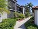 Exterior building view of tropical condo with lush landscaping at 6611 Grand Estuary Trl # 105, Bradenton, FL 34212